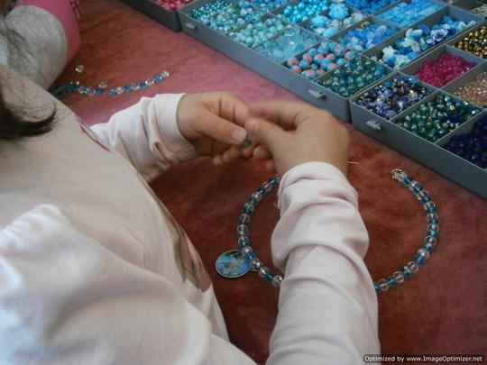 making beaded necklaces during Sparkly Necklace girls party